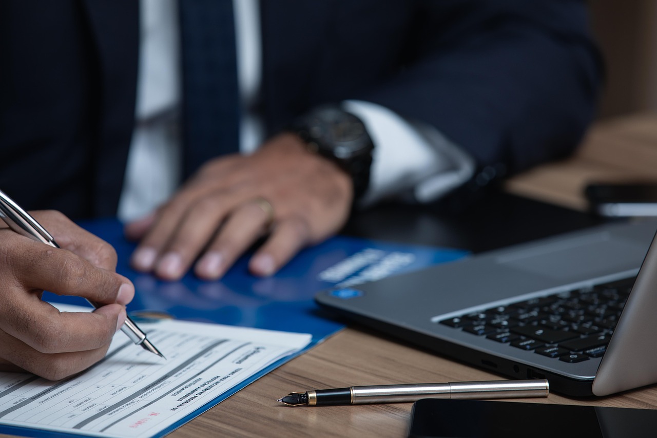 Property ownership documents being signed at a desk