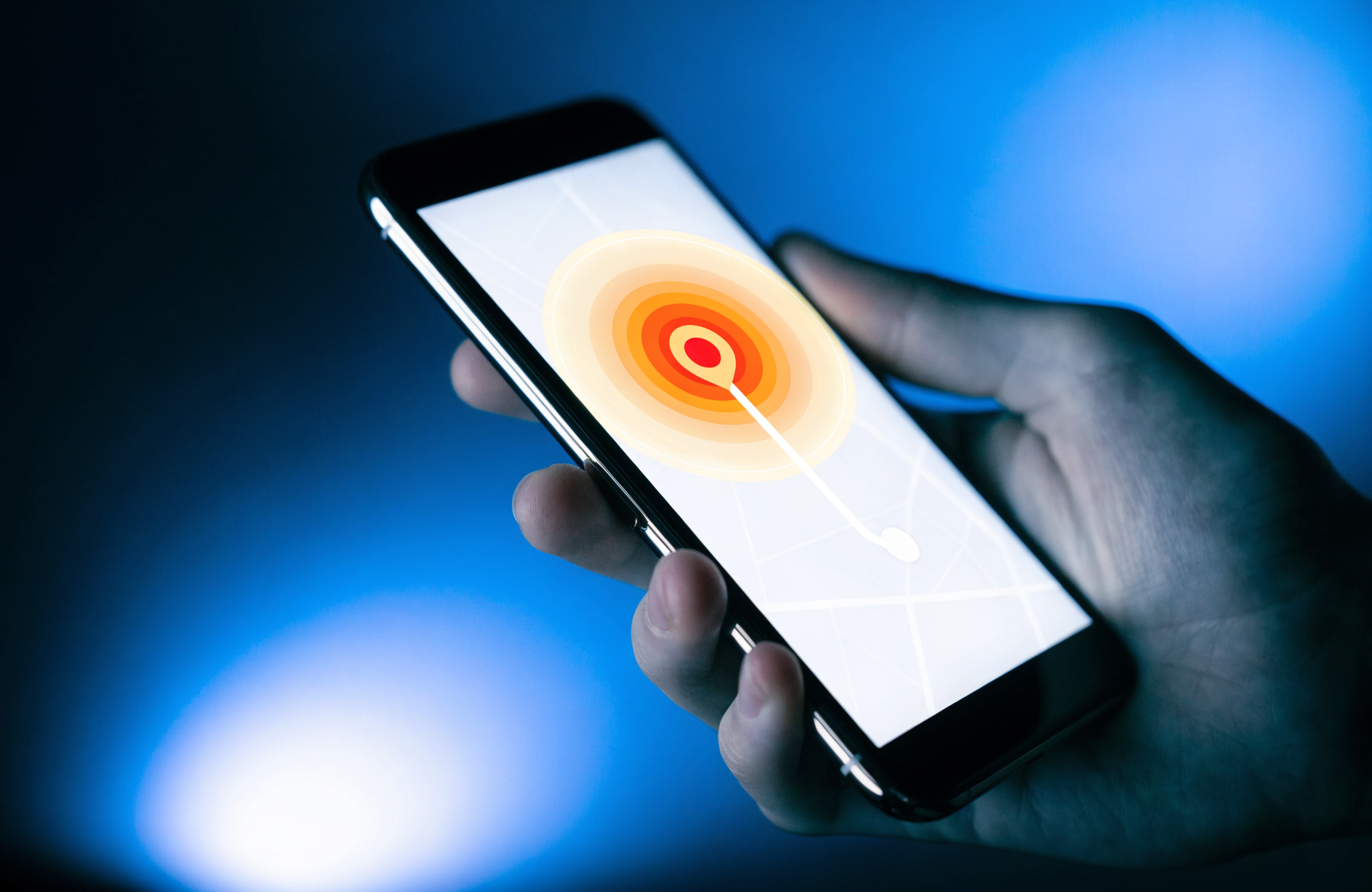 A smartphone held in hand showing a glowing local map pin, styled in Wise Media navy and electric blue brand colors