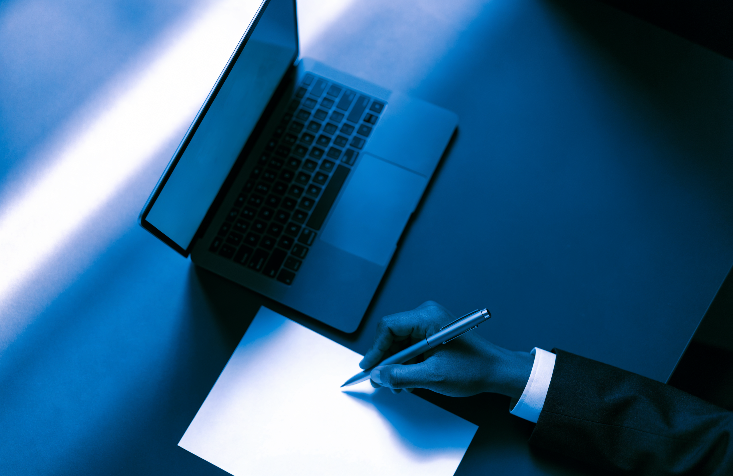 A hand signing a mortgage application document beside an open laptop, styled in Wise Media navy and blue brand colors