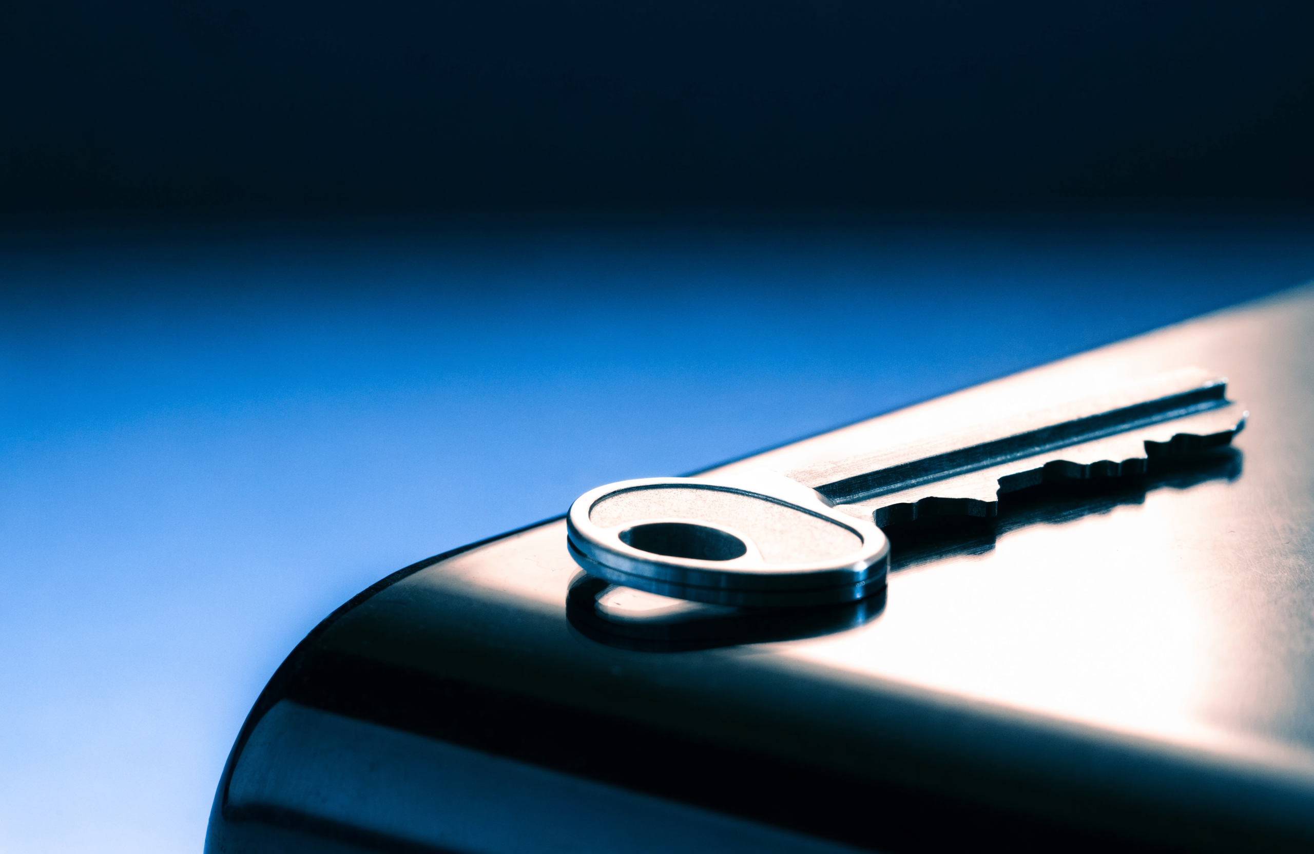 A single house key photographed against a navy-to-blue gradient background in Wise Media brand colors, representing a completed mortgage approval