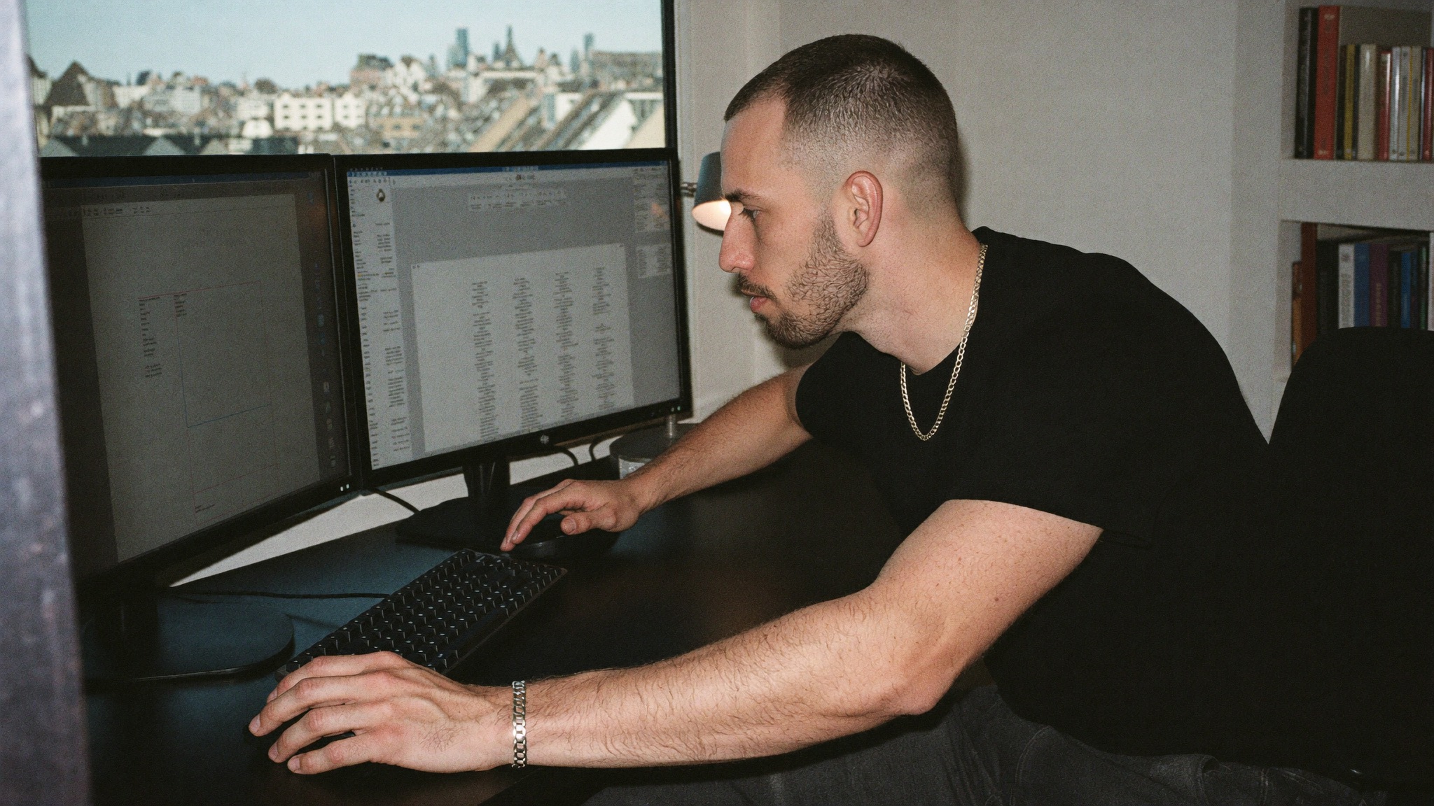 A founder reviewing code and data on a multi monitor workstation