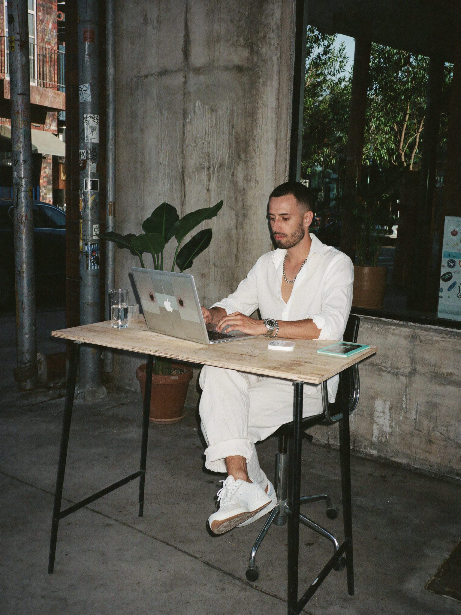 A founder working on a laptop at a street cafe table