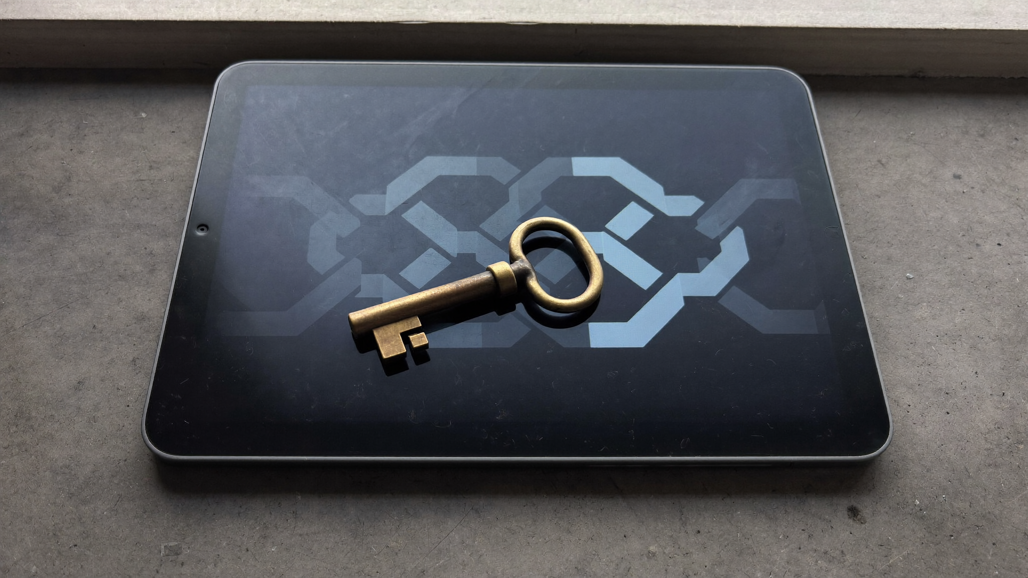A brass door key resting on a tablet showing an abstract chain of blocks
