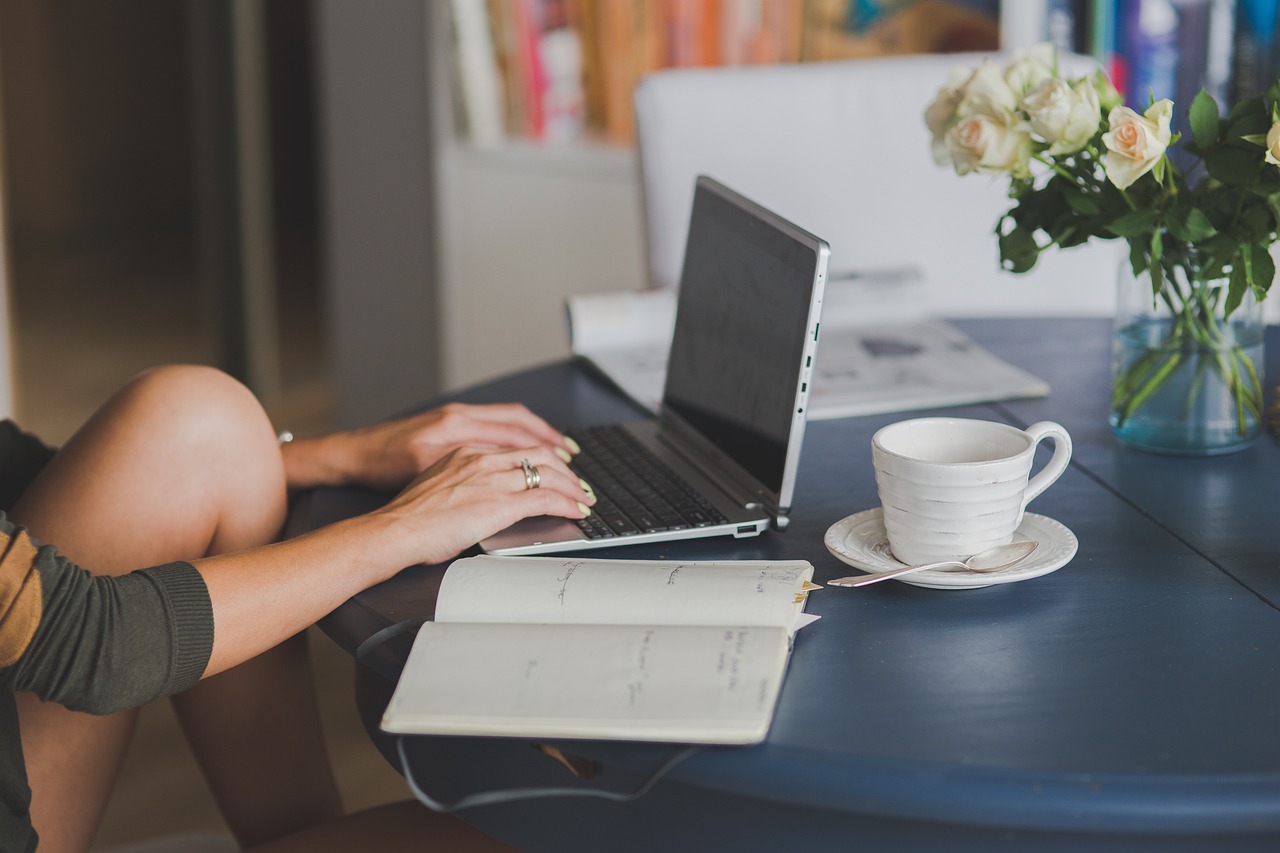 A person typing on a laptop in natural light, illustrating a customer conversation with a website chatbot.
