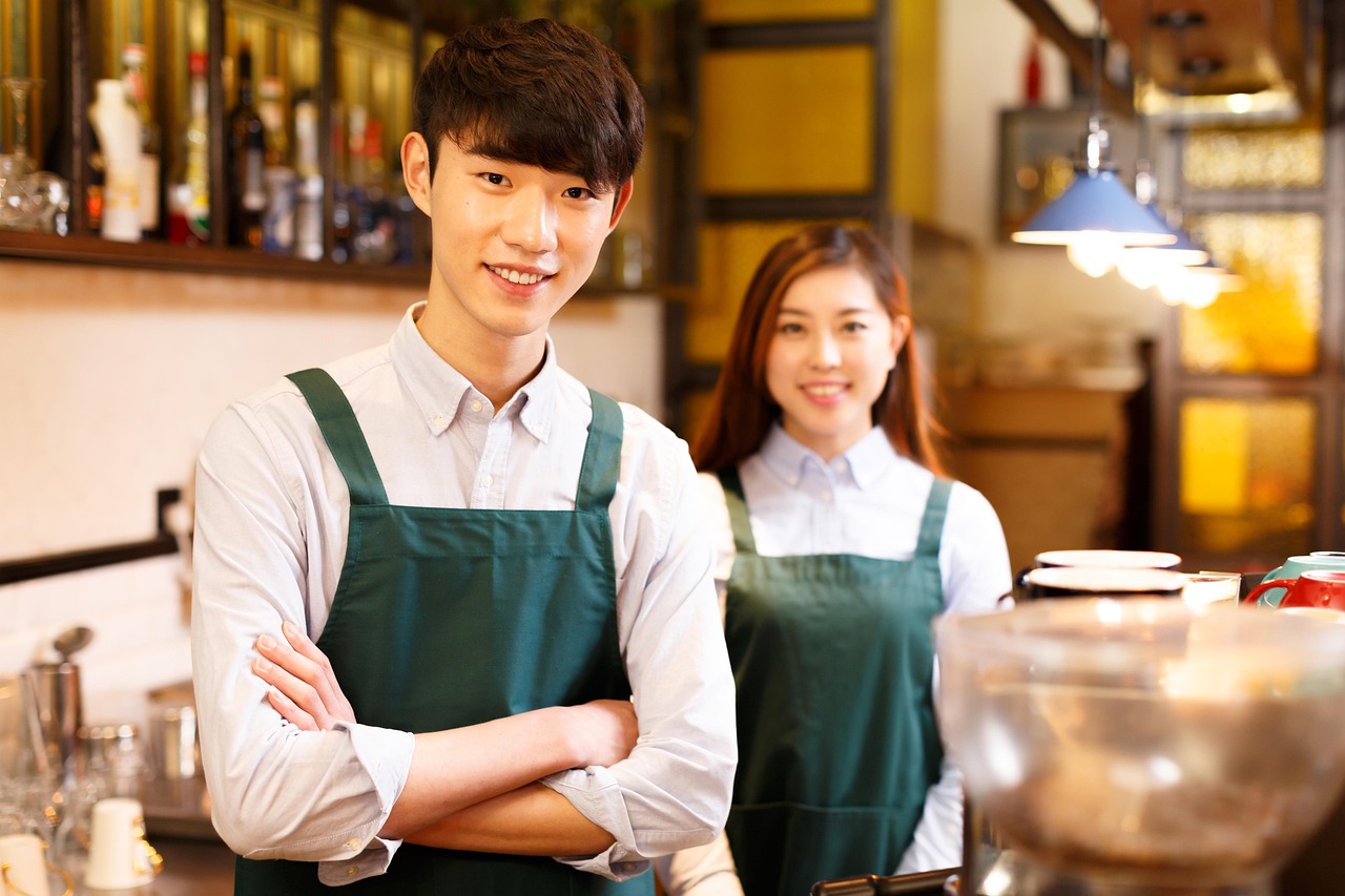 Two front of house staff members in aprons, the people whose review request script now decides whether a business is inside or outside Google policy.