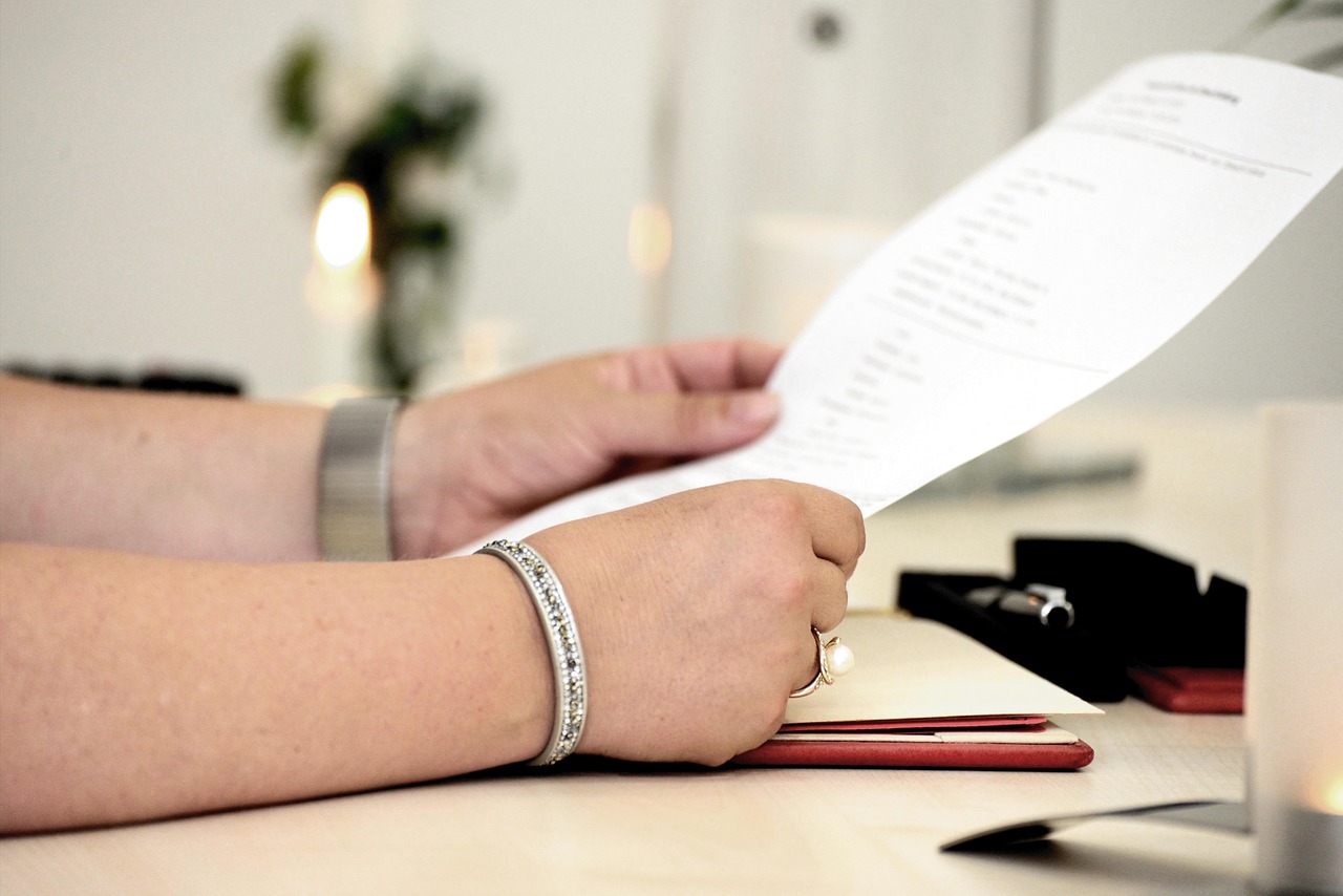Hands holding a printed policy document at a desk, representing the plain-language readability standard Canadian privacy law expects